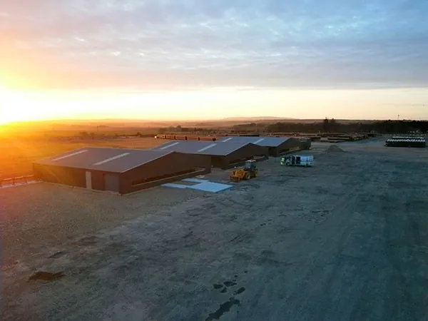 A row of large steel industrial units at sunset